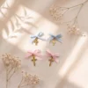 Patru cruciulite aurii de botez cu fundite bleu si roz Patru cruciulite aurii de botez cu fundite bleu si roz