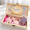 Interiorul cutiei cu Doamna Educatoare si numele pe o carte deschisa cu flori, esarfa de satin roz si odorizant de dulap lila