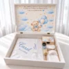 Ursulețul din Nori cu Baloane Trusou botez fără lumânare ursuleț cu baloane: cutie albă deschisă, capac cu ursuleț pe nori, textile albe brodate în albastru
