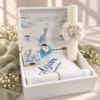 Cutia trusoului Savana Albastra deschisa, cu mesajul nasilor pe capac, prosop cu capison brodat, cutiuta prima suvita si sticluta pentru mir; lumanarea se cumpara separat